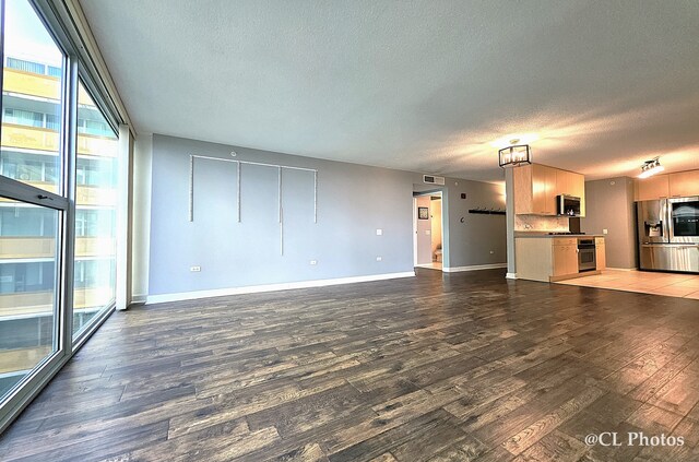 1580 Sherman Ave Unit 1005, Evanston, IL 60201 - unfurnished living room featuring wood finished floors, a textured ceiling, and baseboards