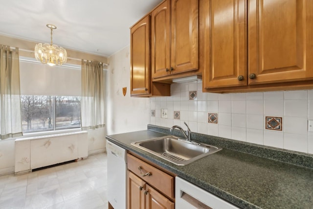 kitchen with dishwasher, a sink, dark countertops, brown cabinetry, and tasteful backsplash