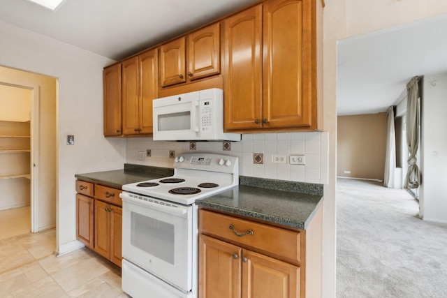 kitchen featuring white appliances, dark countertops, tasteful backsplash, brown cabinetry, and baseboards