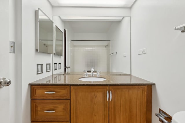full bathroom with vanity, a shower, and toilet