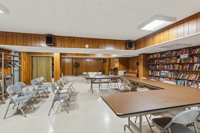 dining space featuring wood walls