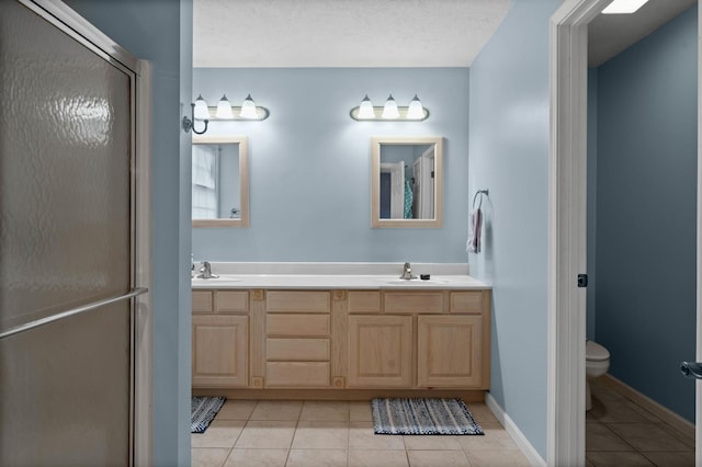 421 Sunset Dr, Colfax, IL 61728 - bathroom with tile patterned flooring, toilet, double vanity, a stall shower, and baseboards