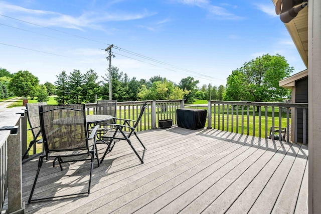 421 Sunset Dr, Colfax, IL 61728 - wooden deck with outdoor dining area, view of wooded area, and a lawn