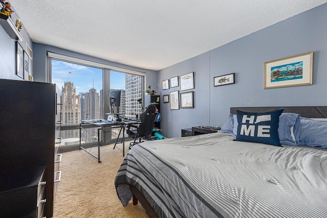 carpeted bedroom with a view of city, a desk, and a textured ceiling