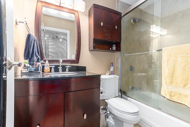 bathroom featuring vanity, bath / shower combo with glass door, and toilet