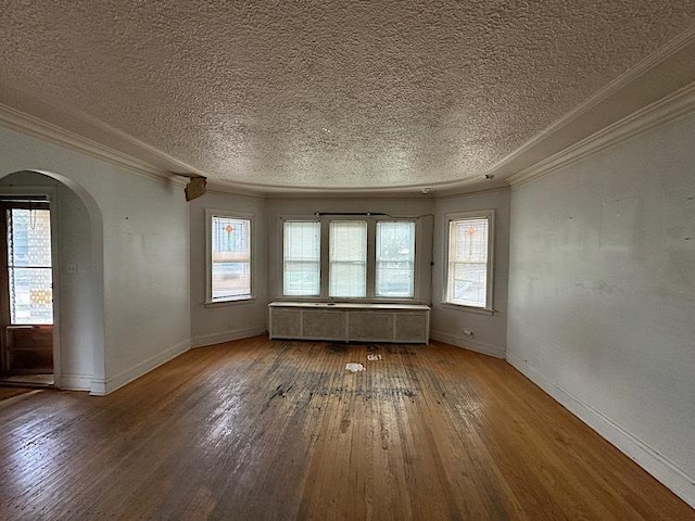 3010 N Nottingham Ave, Chicago, IL 60634 - unfurnished room featuring radiator heating unit, arched walkways, hardwood / wood-style floors, a textured ceiling, and ornamental molding