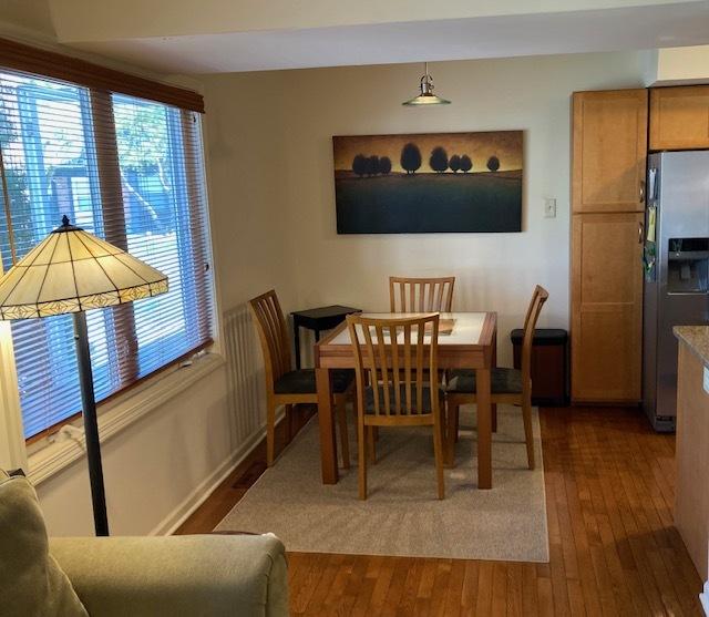 dining space with wood-type flooring