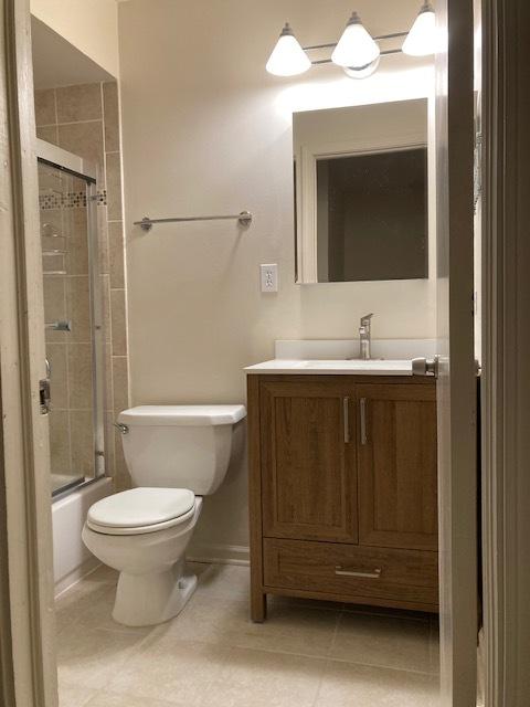 full bathroom with vanity, toilet, and combined bath / shower with glass door