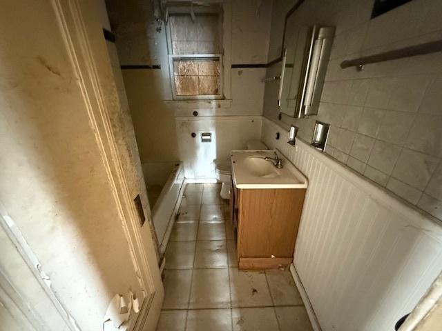 2843 N New England Ave, Chicago, IL 60634 - bathroom featuring toilet, tile patterned floors, vanity, and a wainscoted wall