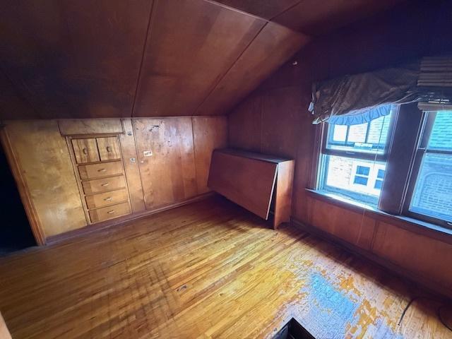 2843 N New England Ave, Chicago, IL 60634 - additional living space with wood finished floors, vaulted ceiling, and wood walls