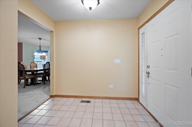 513 Coventry Ct, Oswego, IL 60543 - foyer entrance with a chandelier, light tile patterned floors, baseboards, and light carpet