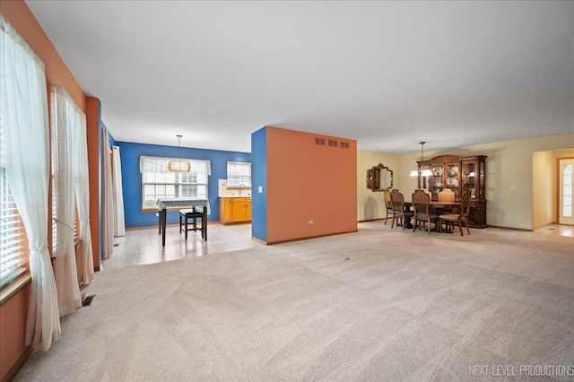 513 Coventry Ct, Oswego, IL 60543 - living room with a chandelier, light carpet, and baseboards
