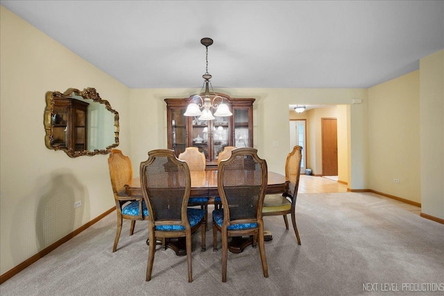 513 Coventry Ct, Oswego, IL 60543 - dining room featuring baseboards, a chandelier, and light colored carpet