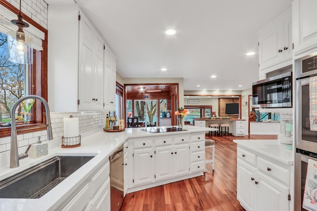 2407 N Villa Ln, Mchenry, IL 60051 - kitchen with a sink, light wood-type flooring, stainless steel appliances, decorative backsplash, and light countertops