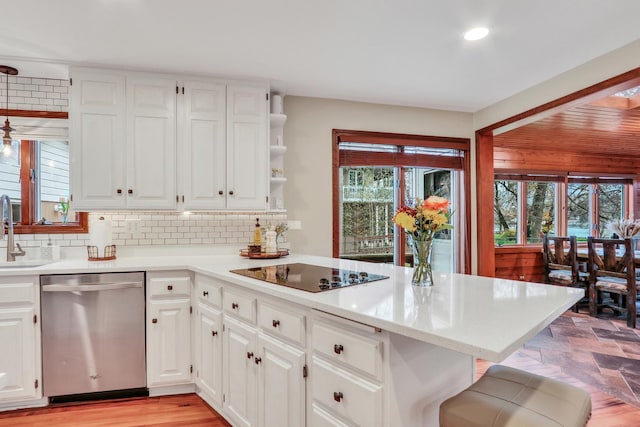 2407 N Villa Ln, Mchenry, IL 60051 - kitchen featuring stainless steel dishwasher, black electric stovetop, a sink, decorative backsplash, and light countertops