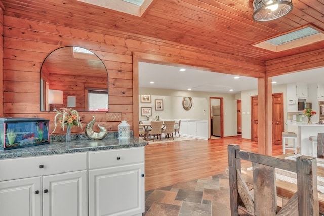 2407 N Villa Ln, Mchenry, IL 60051 - kitchen featuring a skylight, wood ceiling, white cabinetry, wooden walls, and recessed lighting