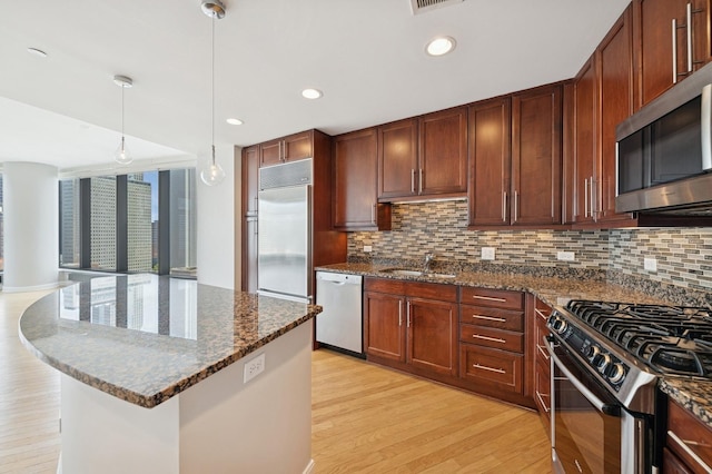 60 E Monroe St Unit 3007, Chicago, IL 60603 - kitchen with stainless steel appliances, a sink, light wood-type flooring, tasteful backsplash, and dark stone countertops