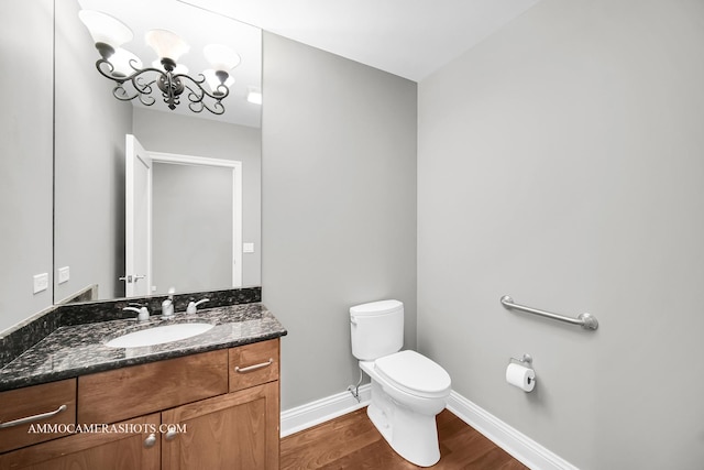 520 S Washington St Unit 201, Naperville, IL 60540 - bathroom featuring wood finished floors, toilet, baseboards, vanity, and a chandelier