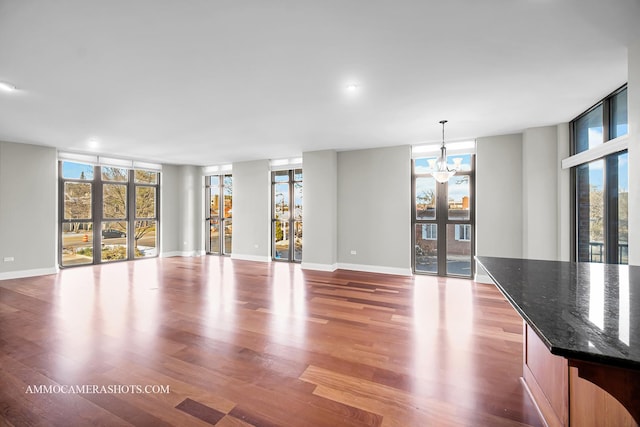 520 S Washington St Unit 201, Naperville, IL 60540 - unfurnished living room with wood finished floors, a chandelier, baseboards, and recessed lighting