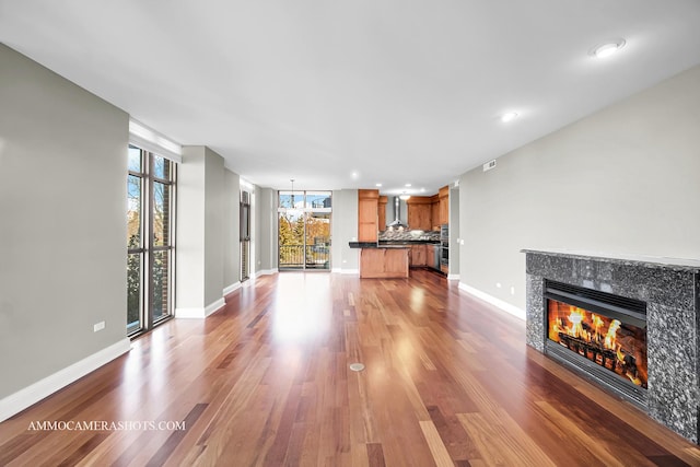 520 S Washington St Unit 201, Naperville, IL 60540 - unfurnished living room with a tiled fireplace, wood finished floors, baseboards, and recessed lighting