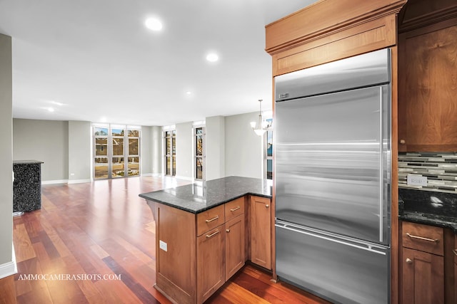 520 S Washington St Unit 201, Naperville, IL 60540 - kitchen featuring built in fridge, backsplash, dark wood finished floors, dark stone countertops, and recessed lighting