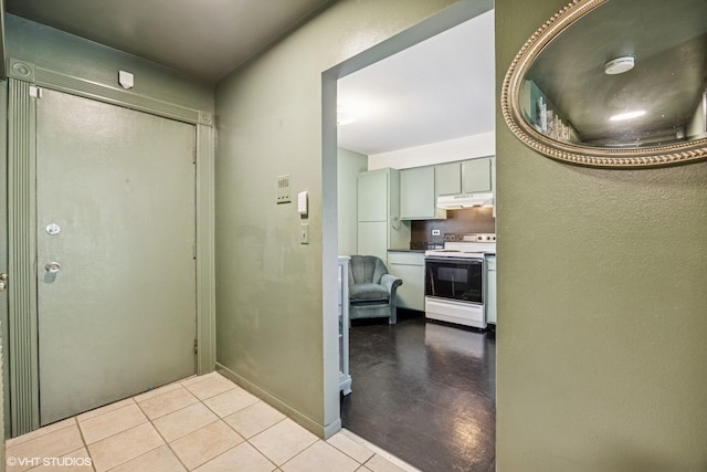 hall featuring tile patterned floors and baseboards