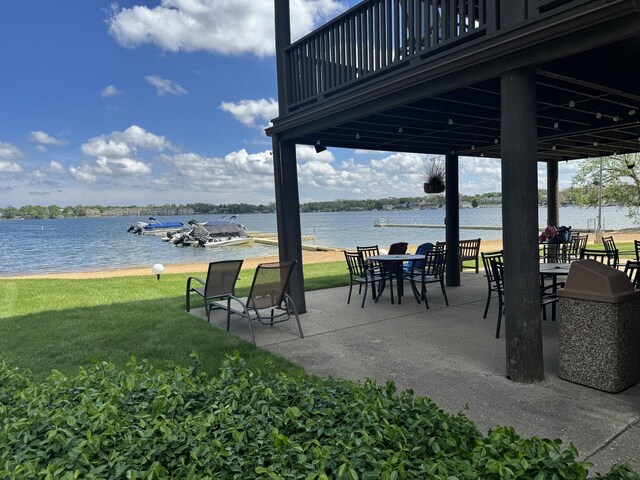 view of community with a yard, a water view, and a patio