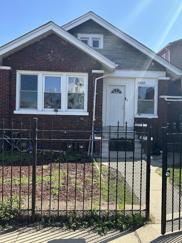 view of front facade with brick siding and a fenced front yard