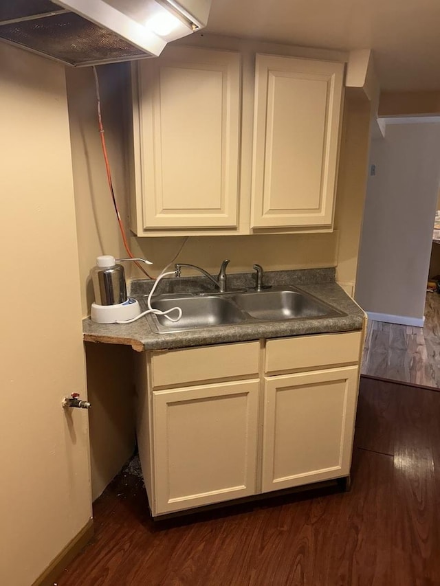 washroom with a sink, dark wood finished floors, and baseboards
