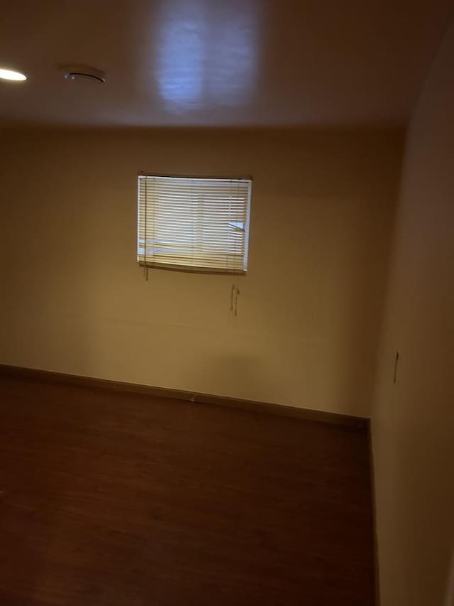 unfurnished room with wood finished floors and baseboards