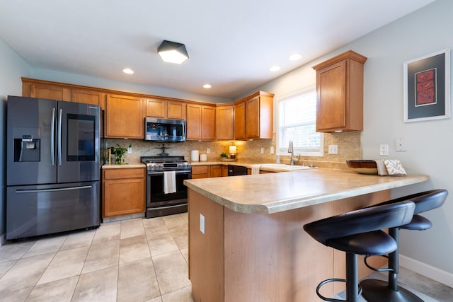 502 Deerpath St, Tolono, IL 61880 - kitchen with appliances with stainless steel finishes, light countertops, a peninsula, decorative backsplash, and recessed lighting