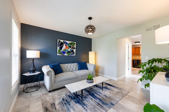 502 Deerpath St, Tolono, IL 61880 - living room featuring baseboards, light tile patterned flooring, and an accent wall