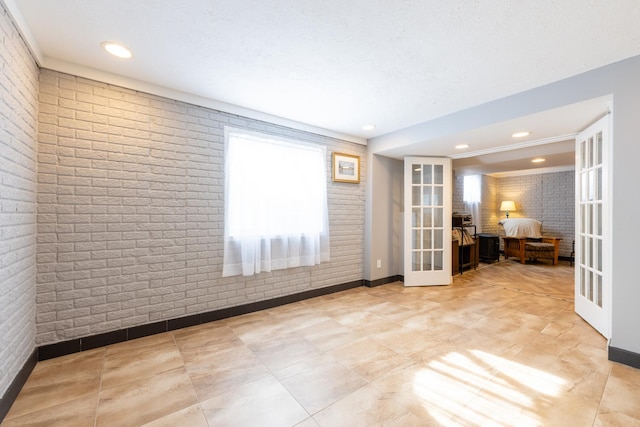 502 Deerpath St, Tolono, IL 61880 - unfurnished room with french doors, baseboards, recessed lighting, and brick wall