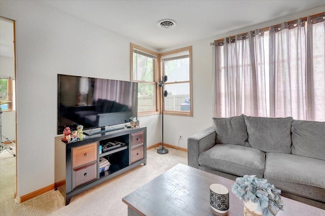 living area featuring light colored carpet and baseboards