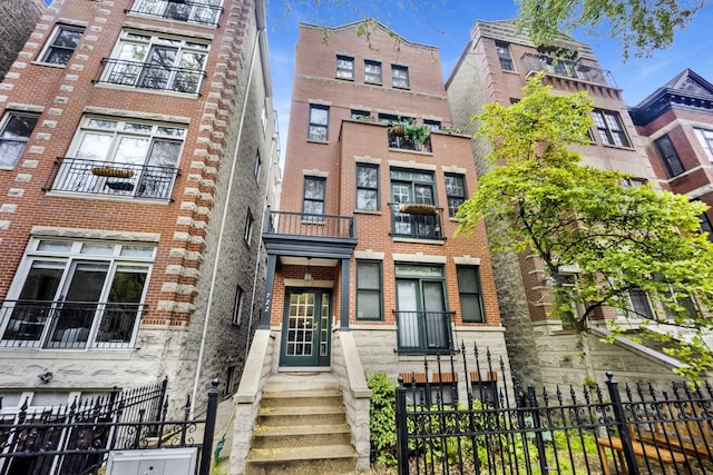 722 W Briar St Unit 2, Chicago, IL 60657 - view of front facade with brick siding, a fenced front yard, and entry steps