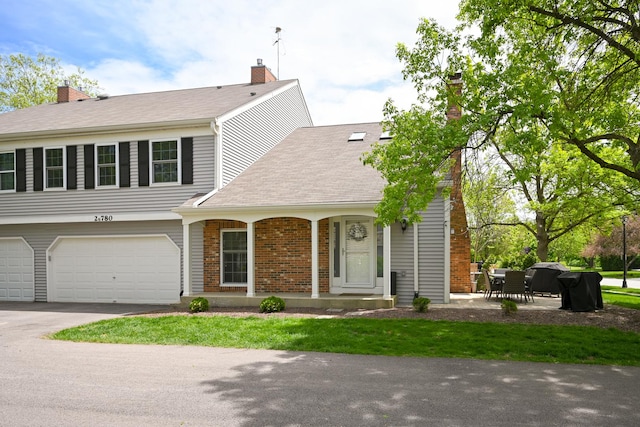 2S780 Grove Ln Unit 26-A, Warrenville, IL 60555 - view of front of house featuring a chimney, asphalt driveway, an attached garage, and a porch