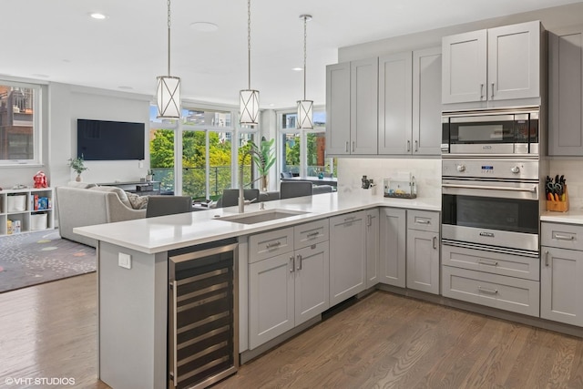 236 S Racine Ave Unit 304, Chicago, IL 60607 - kitchen featuring beverage cooler, stainless steel appliances, gray cabinetry, a peninsula, and dark wood finished floors