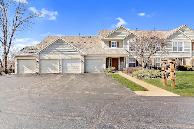 view of front of property with asphalt driveway and a garage