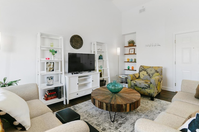 living area with high vaulted ceiling, dark wood-type flooring, and baseboards