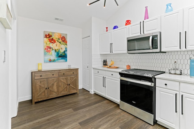 kitchen featuring stainless steel appliances, dark wood-style floors, tasteful backsplash, white cabinetry, and baseboards