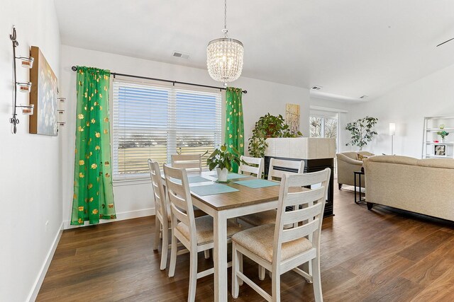 dining room with wood finished floors, a chandelier, and baseboards