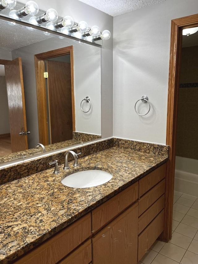 bathroom featuring tile patterned floors, vanity, and a textured ceiling