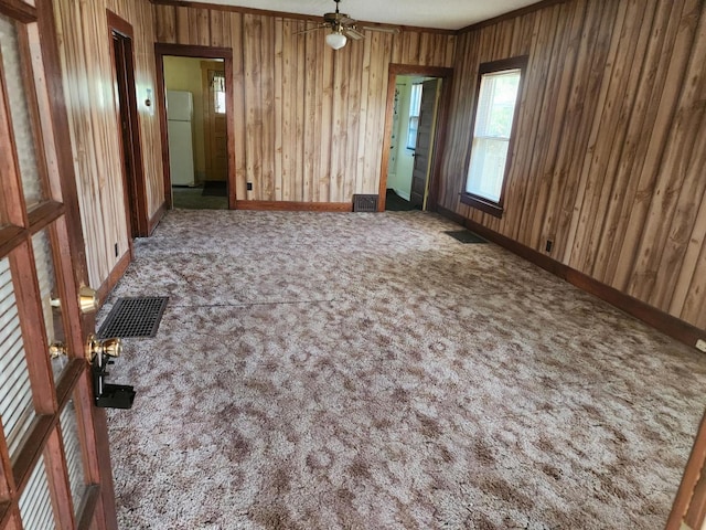931 S Nelson Ave, Kankakee, IL 60901 - carpeted spare room featuring wood walls, ceiling fan, and baseboards