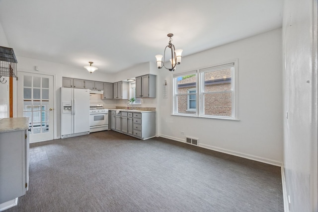 kitchen featuring gray cabinets, white appliances, light countertops, a chandelier, and dark colored carpet