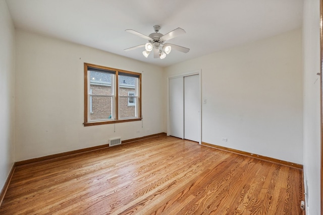 empty room featuring light wood-style floors, baseboards, and a ceiling fan