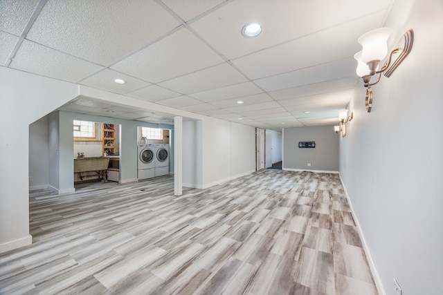 basement featuring washing machine and clothes dryer, wood finished floors, baseboards, recessed lighting, and a paneled ceiling
