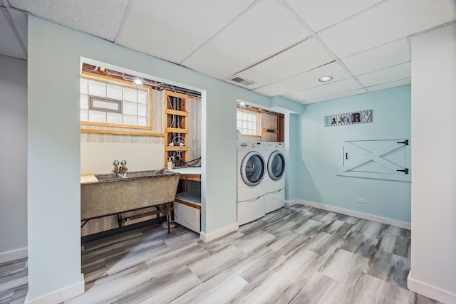 laundry room featuring washing machine and dryer, wood finished floors, and baseboards