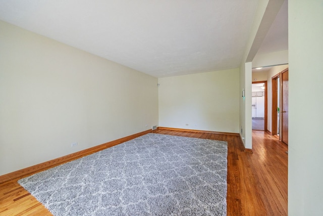 spare room featuring wood finished floors and baseboards