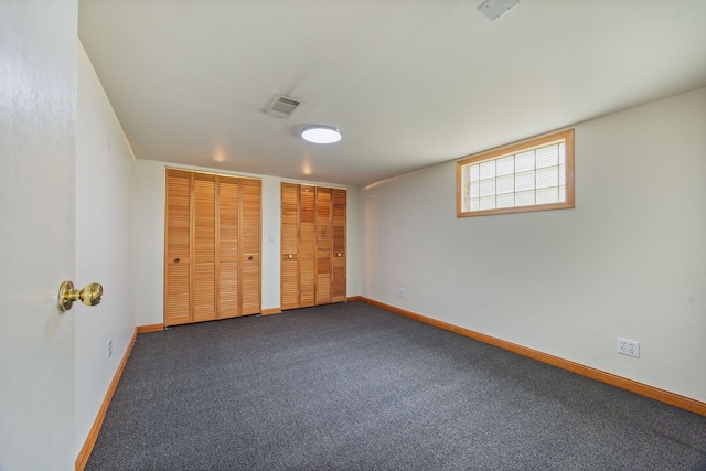 unfurnished bedroom featuring multiple closets, baseboards, and carpet floors