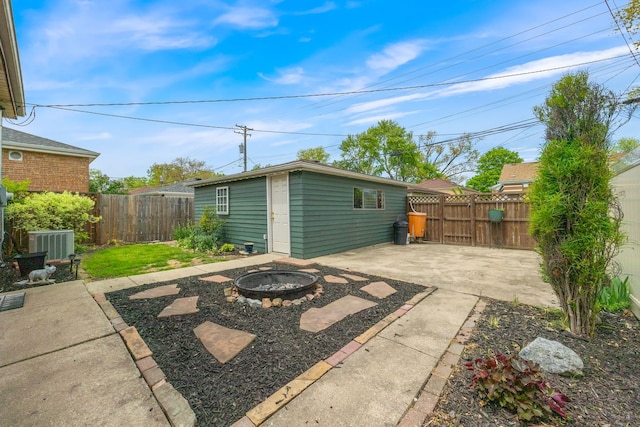 view of patio / terrace featuring an outdoor fire pit, a fenced backyard, and an outbuilding